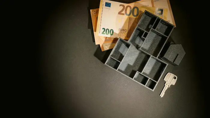 Main tenant un billet de cinquante euros reflétant la vigilance et la discipline nécessaires pour constituer le capital social d’une SCI.