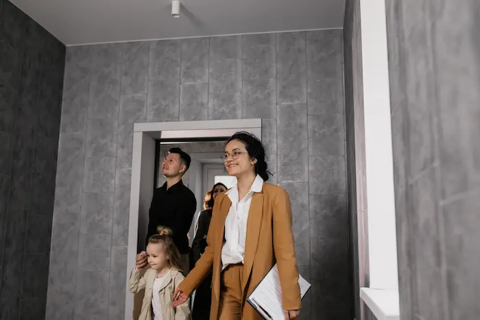 Groupe de personnes observant une pièce moderne, image qui illustre le processus de visiter un appartement locatif.