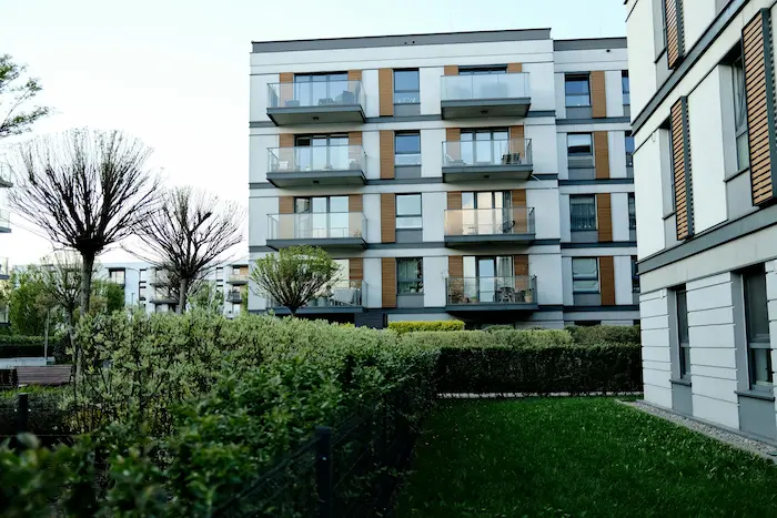 Résidence moderne aux lignes épurées avec balcons vitrés et espaces verts, idéale pour un achat d’appartement ancien