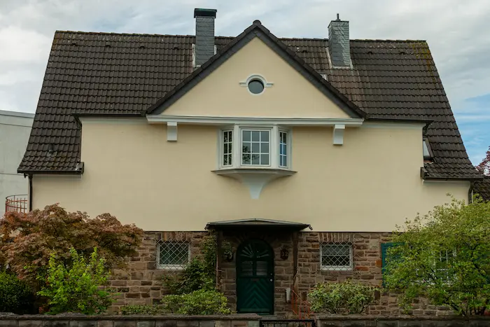 Façade d une maison au style traditionnel incarnant le charme et l élégance intemporelle d un bien immobilier ancien avec ses murs en pierre et son toit en tuiles