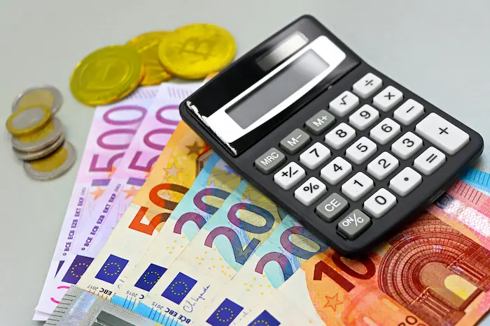 Billets et pièces d’euros reflétant la rigueur et la précision nécessaires pour calculer les revenus immobiliers.