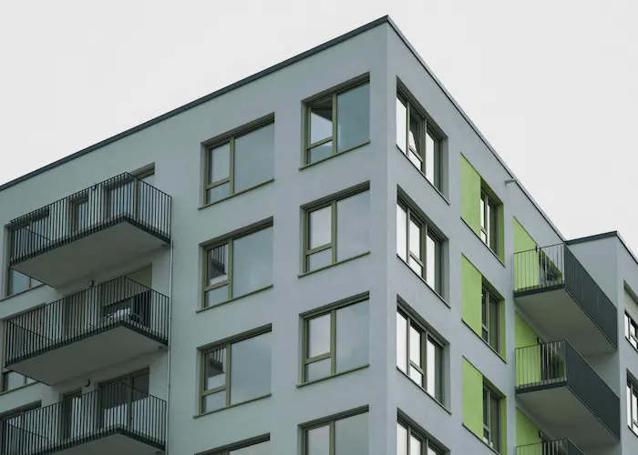 Immeuble moderne aux façades grises et vertes, illustration de l’achat d’un immeuble pour un investissement locatif.